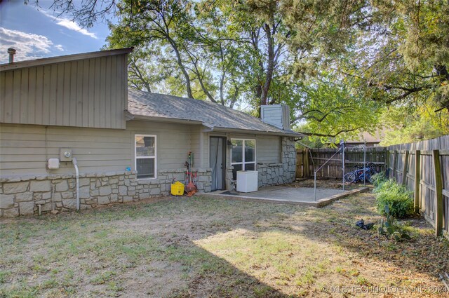 rear view of house featuring a yard and a patio area