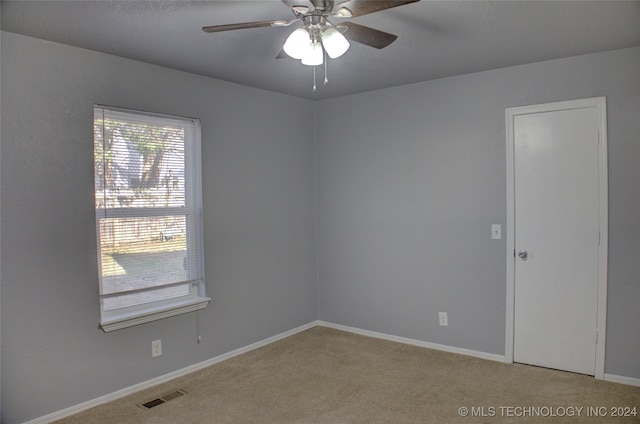 unfurnished room with carpet, a wealth of natural light, and ceiling fan