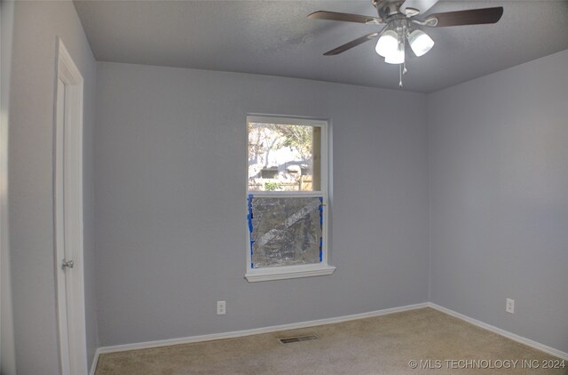 empty room with ceiling fan and carpet floors