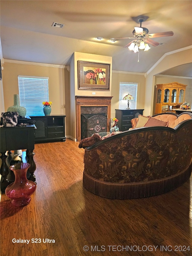 living room featuring crown molding, a healthy amount of sunlight, wood-type flooring, and lofted ceiling