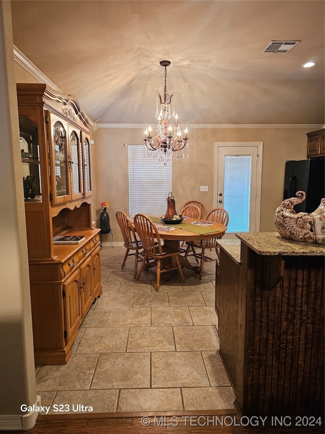 dining room with crown molding, a chandelier, and lofted ceiling