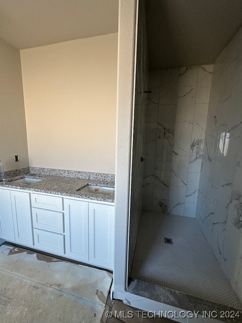 bathroom featuring vanity and tiled shower