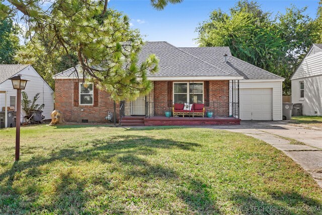 single story home with a garage, a porch, and a front yard