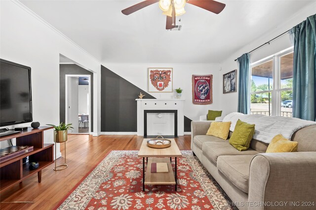 living room with ornamental molding, hardwood / wood-style flooring, and ceiling fan