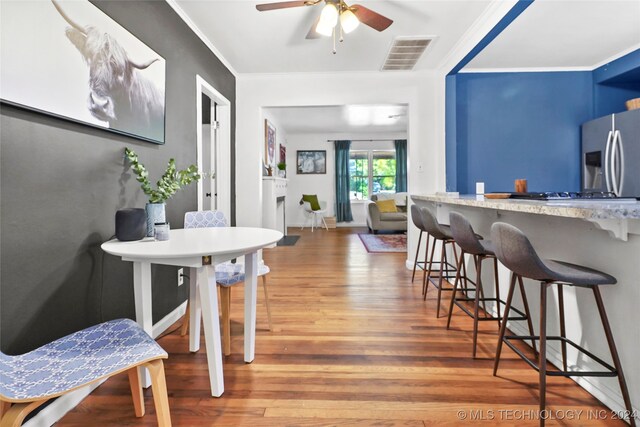 dining area with ornamental molding, hardwood / wood-style flooring, and ceiling fan