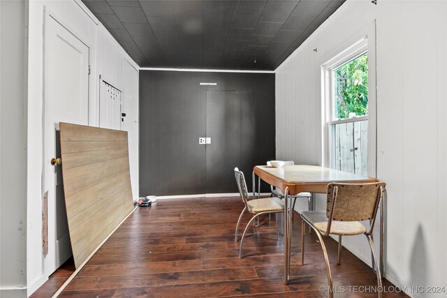 dining space featuring wood walls and dark hardwood / wood-style flooring