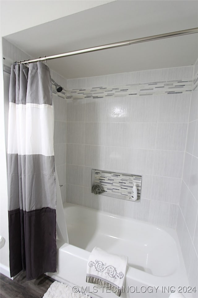 bathroom featuring shower / tub combo with curtain and hardwood / wood-style floors