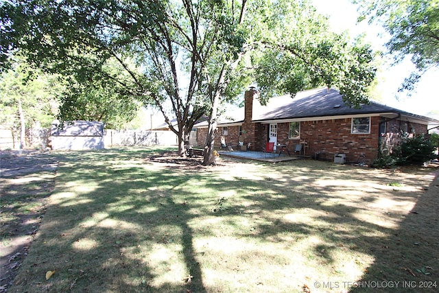 view of yard featuring a shed and a patio