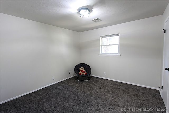 carpeted spare room featuring a textured ceiling