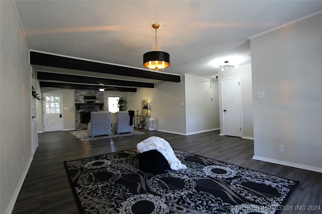 living room with beam ceiling, dark hardwood / wood-style flooring, ornamental molding, and a fireplace