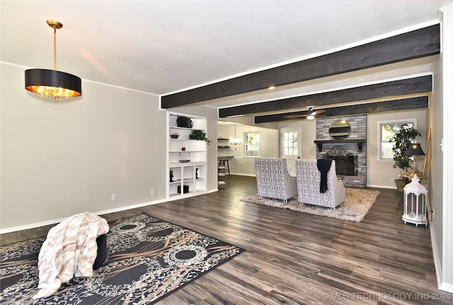 living room featuring beam ceiling, dark hardwood / wood-style flooring, ceiling fan, and a fireplace