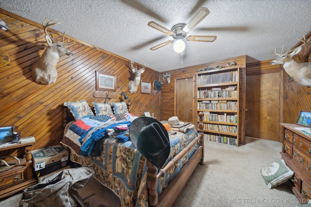 bedroom featuring ceiling fan, wood walls, and a textured ceiling