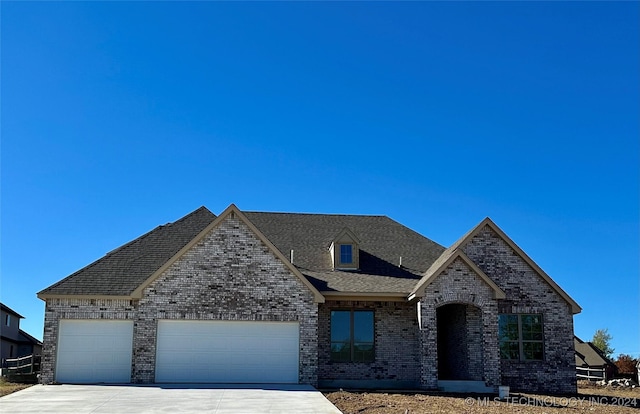 french provincial home featuring a garage