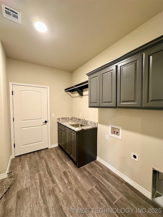 clothes washing area with sink, cabinets, dark hardwood / wood-style floors, electric dryer hookup, and washer hookup