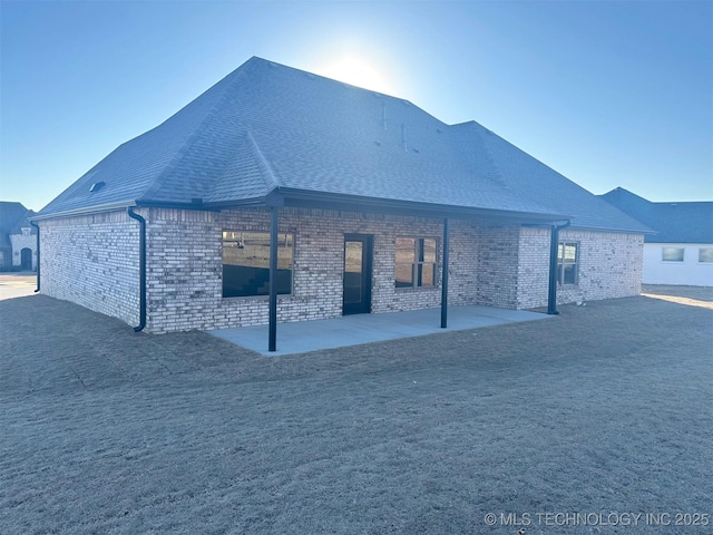 back of property featuring a yard and a patio area