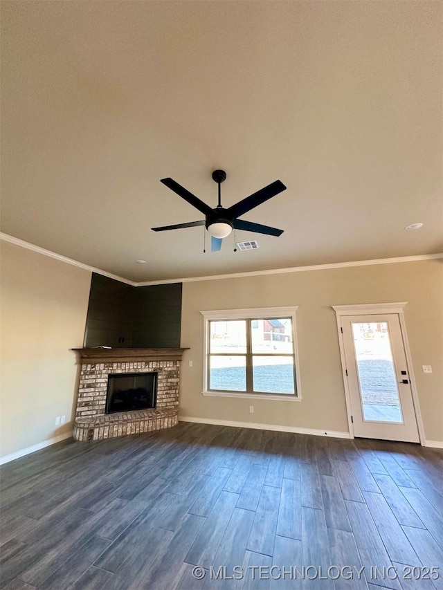 unfurnished living room with hardwood / wood-style floors, crown molding, a brick fireplace, and ceiling fan