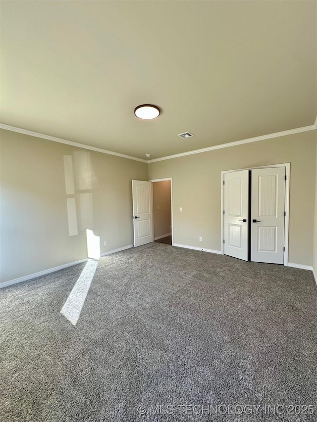 spare room with ornamental molding and carpet floors