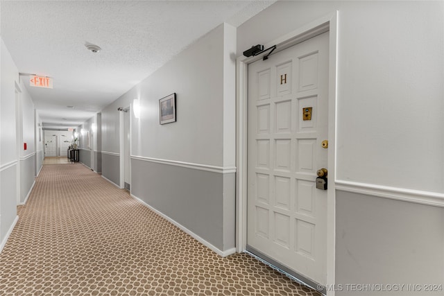 hall with a textured ceiling