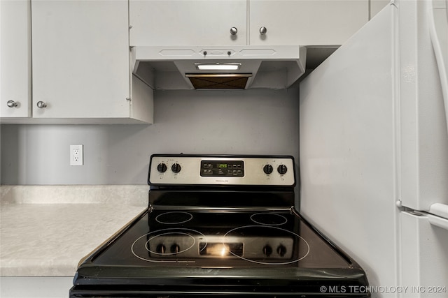 kitchen featuring extractor fan, stainless steel range with electric cooktop, white cabinets, and white refrigerator