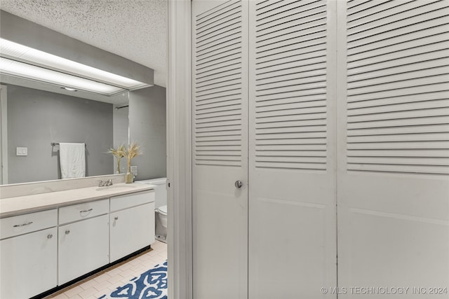 bathroom with vanity, tile patterned flooring, and toilet