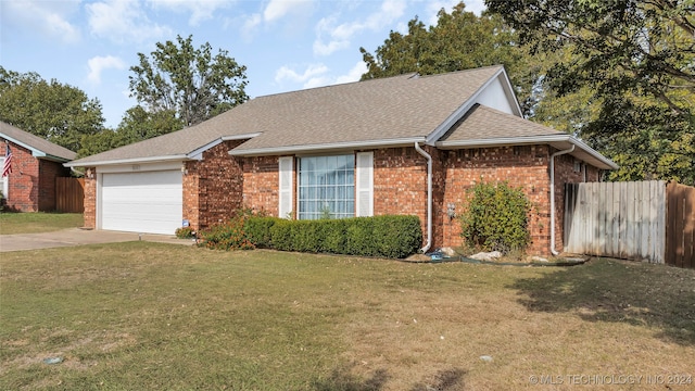 ranch-style home featuring a garage and a front lawn