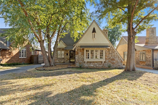 english style home with a front yard