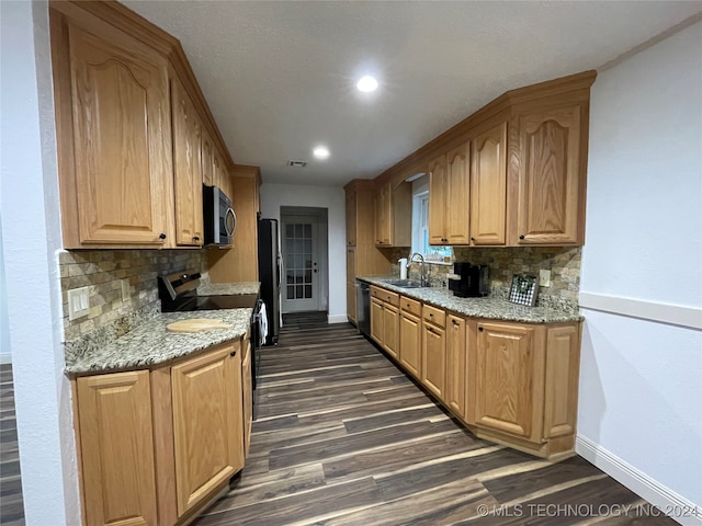 kitchen featuring decorative backsplash, light stone counters, dark hardwood / wood-style floors, sink, and stainless steel appliances