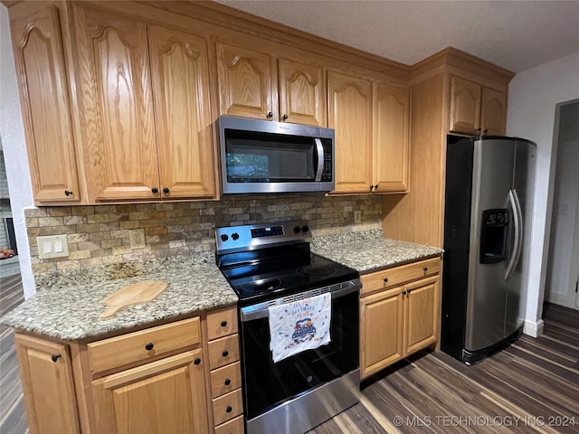 kitchen featuring decorative backsplash, light stone countertops, stainless steel appliances, and dark hardwood / wood-style flooring