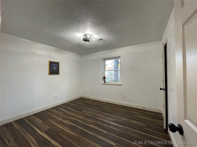 unfurnished room featuring a textured ceiling and dark hardwood / wood-style flooring