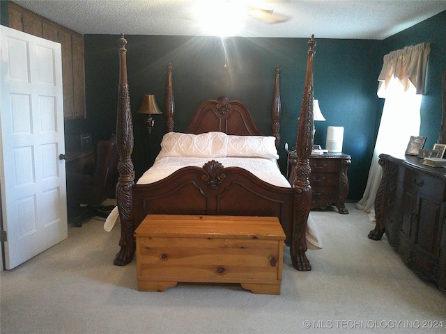 carpeted bedroom featuring ceiling fan and a textured ceiling