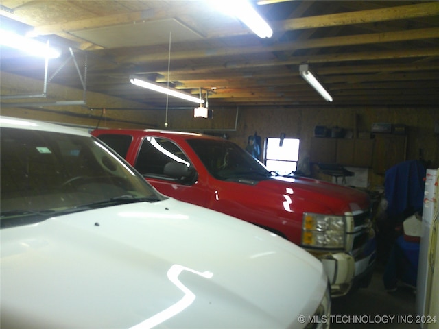 garage with a garage door opener and wooden walls