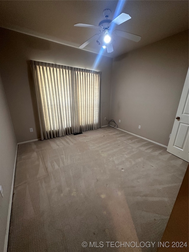 carpeted empty room featuring ceiling fan