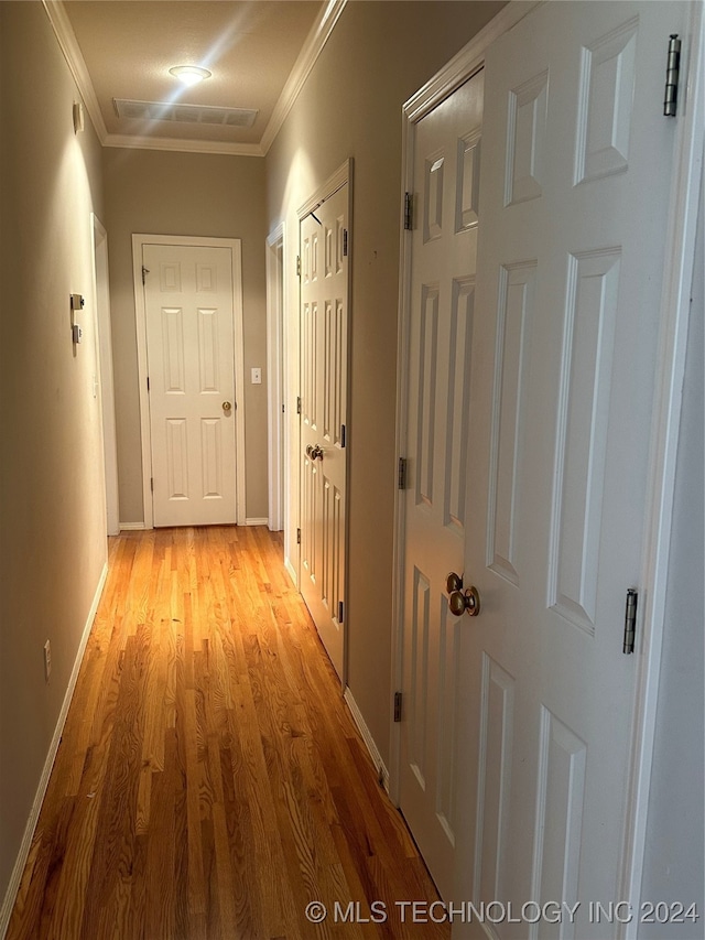 hall with crown molding and light wood-type flooring