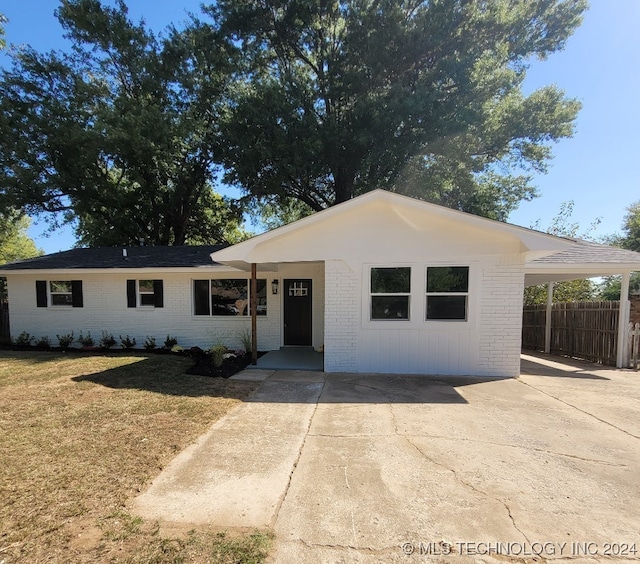 ranch-style home with a carport and a front yard