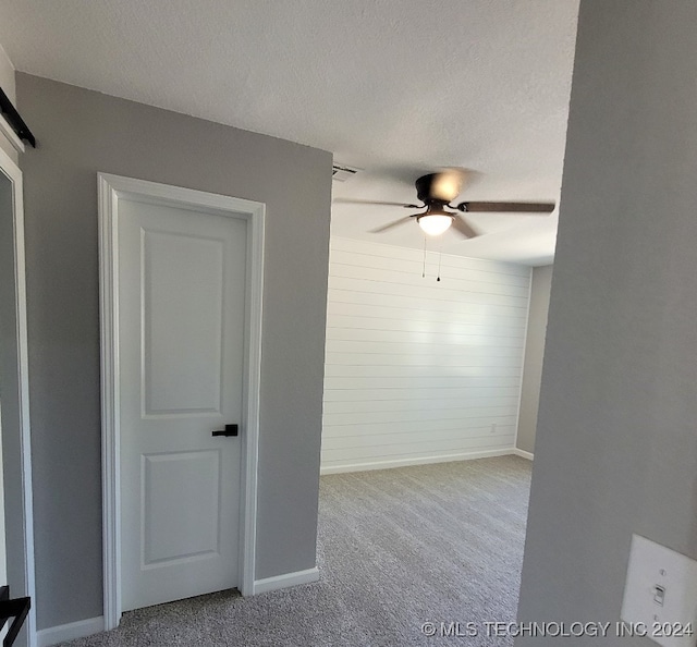 carpeted spare room with ceiling fan and a textured ceiling