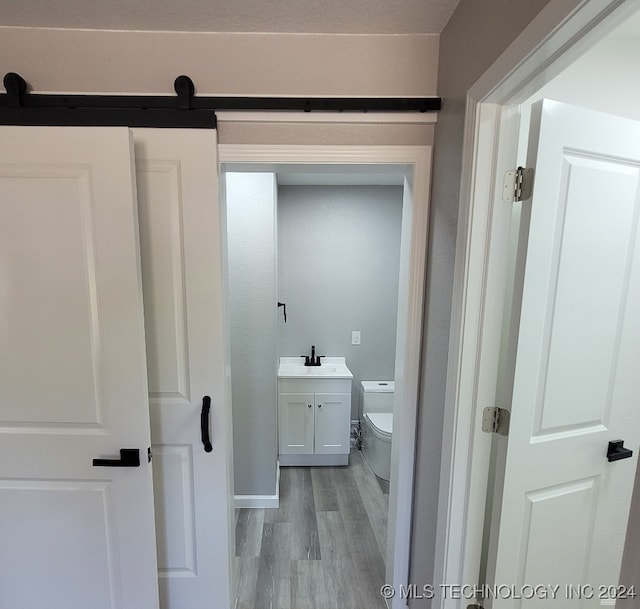 bathroom with hardwood / wood-style floors, vanity, and toilet