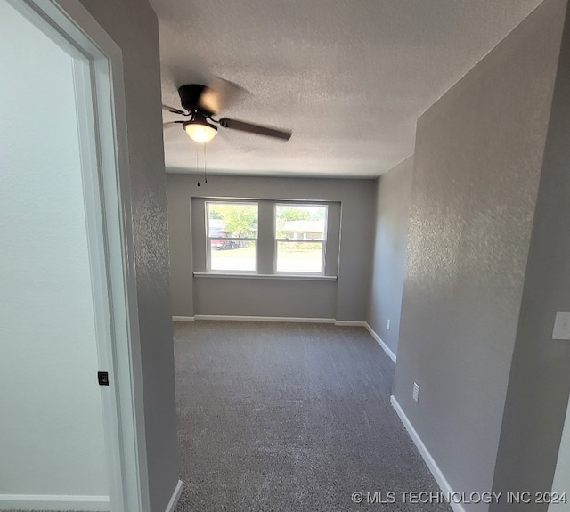 carpeted empty room with ceiling fan and a textured ceiling