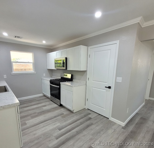 kitchen with white cabinetry, stainless steel appliances, and light hardwood / wood-style flooring