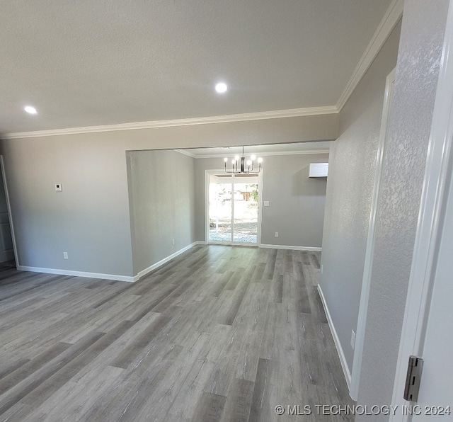 unfurnished room featuring ornamental molding, an inviting chandelier, and light hardwood / wood-style floors