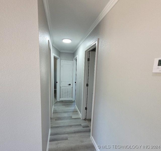 hall with light hardwood / wood-style flooring and crown molding