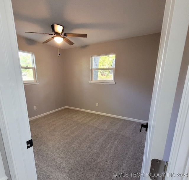 unfurnished room with carpet and ceiling fan