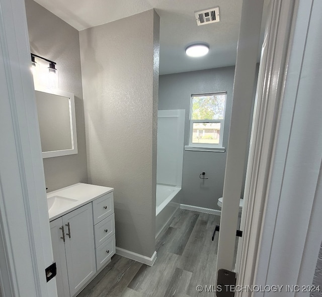 bathroom with hardwood / wood-style floors, vanity, and toilet