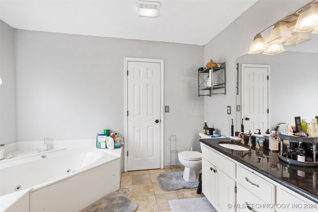 bathroom with vanity, tile patterned floors, toilet, and a bathing tub