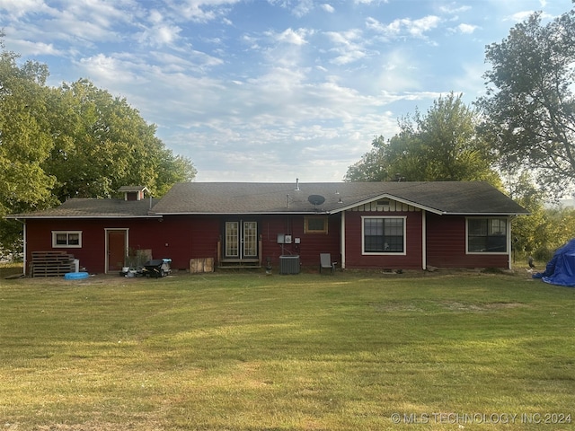 rear view of house featuring a lawn