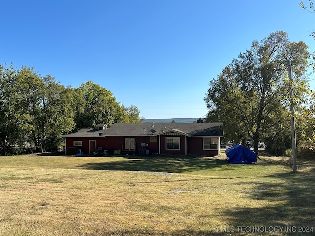 rear view of house featuring a lawn