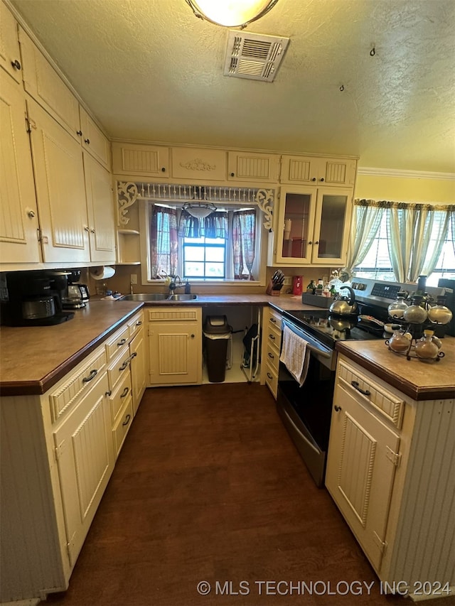 kitchen featuring a textured ceiling, electric range, and dark wood-type flooring