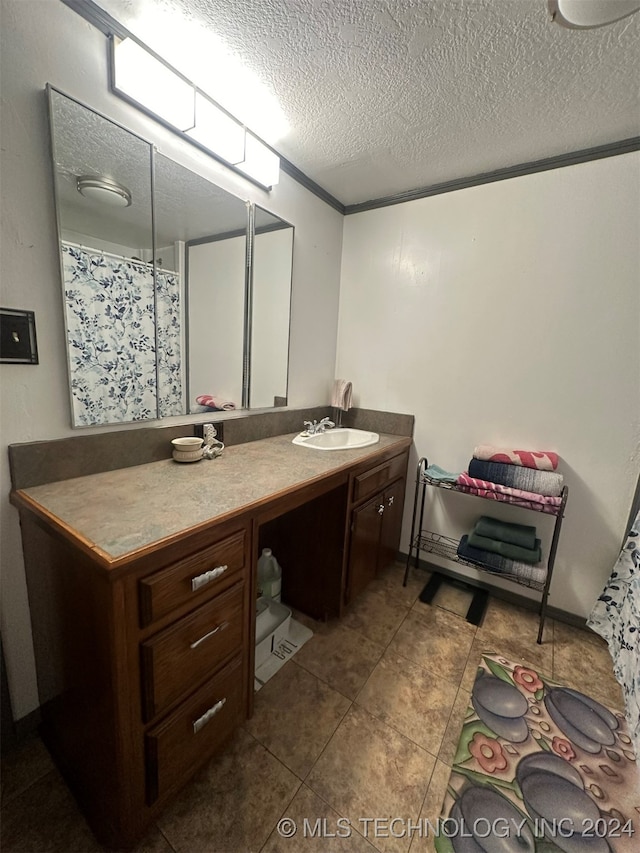 bathroom with tile patterned flooring, vanity, and a textured ceiling