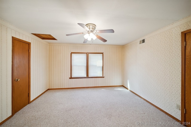 carpeted spare room with ornamental molding and ceiling fan