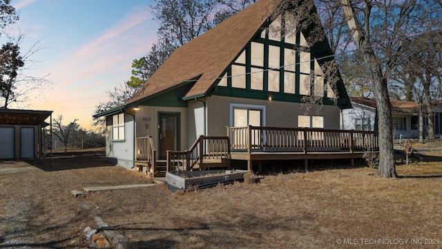 back of house featuring a deck and a shingled roof