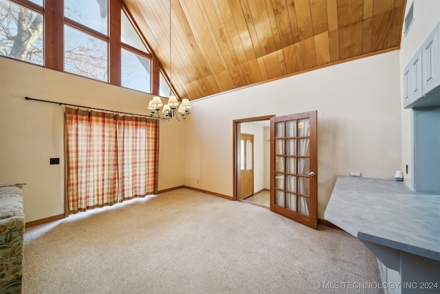 empty room featuring carpet, high vaulted ceiling, an inviting chandelier, and wooden ceiling